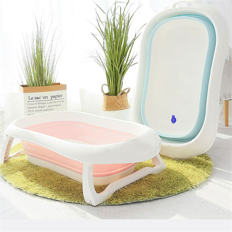 Une baignoire pliable Baignoire pour Bébé - Baby Prema, article indispensable d'hygiène bébé, posée sur un tapis vert dans une pièce lumineuse et cosy avec des plantes décoratives et un "sac en papier" à proximité.