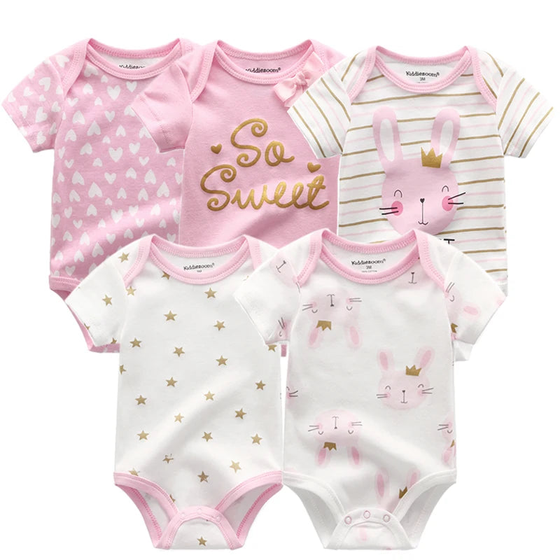 Cinq bodys en coton à manches courtes BABY PREMA pour bébés filles avec divers motifs, notamment des étoiles, des cœurs et un visage de lapin, présentés dans des couleurs rose tendre et blanc.