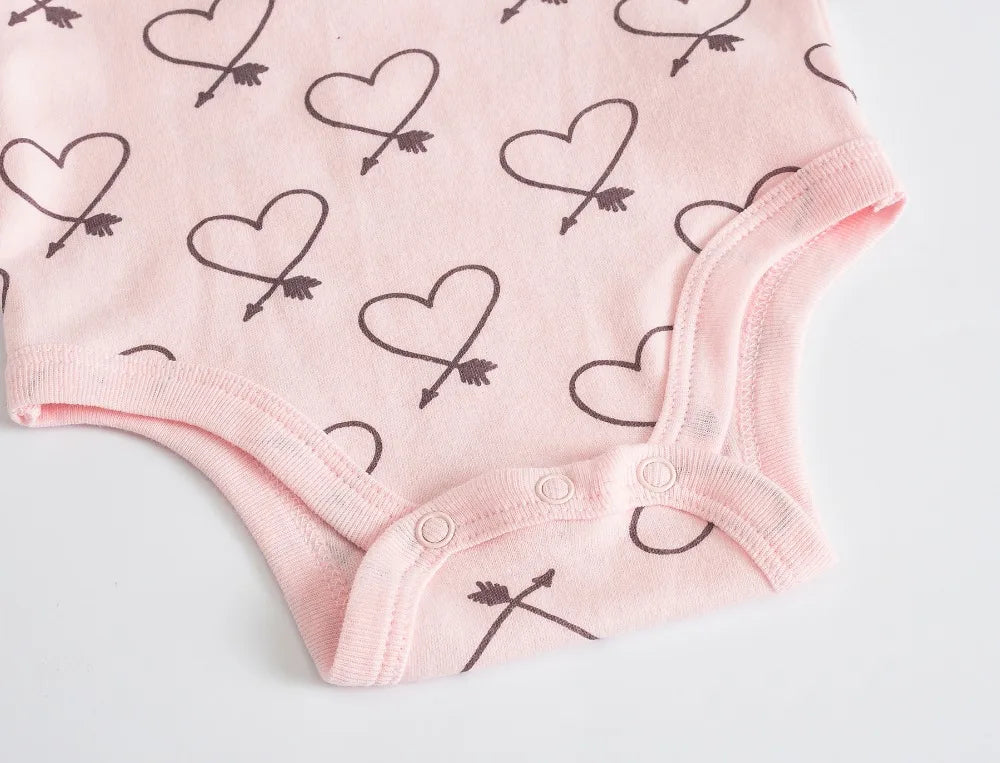 Rose Lot de 7 Bodies Bébé Imprimés Unis avec motif coeur et flèche par BABY-PREMA, avec boutons pression pratiques en bas. Fabriqué à partir de coton doux pour un confort ultime.