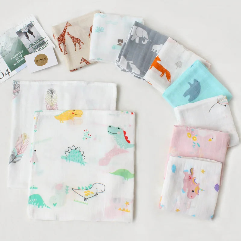 Une collection de mouchoirs colorés pour enfants avec divers animaux mignons, dont des dodo, et des motifs sur le thème de la nature soigneusement affichés sur fond blanc de Lange Mousseline Coton Bio | Emmaillotage de Bébé.