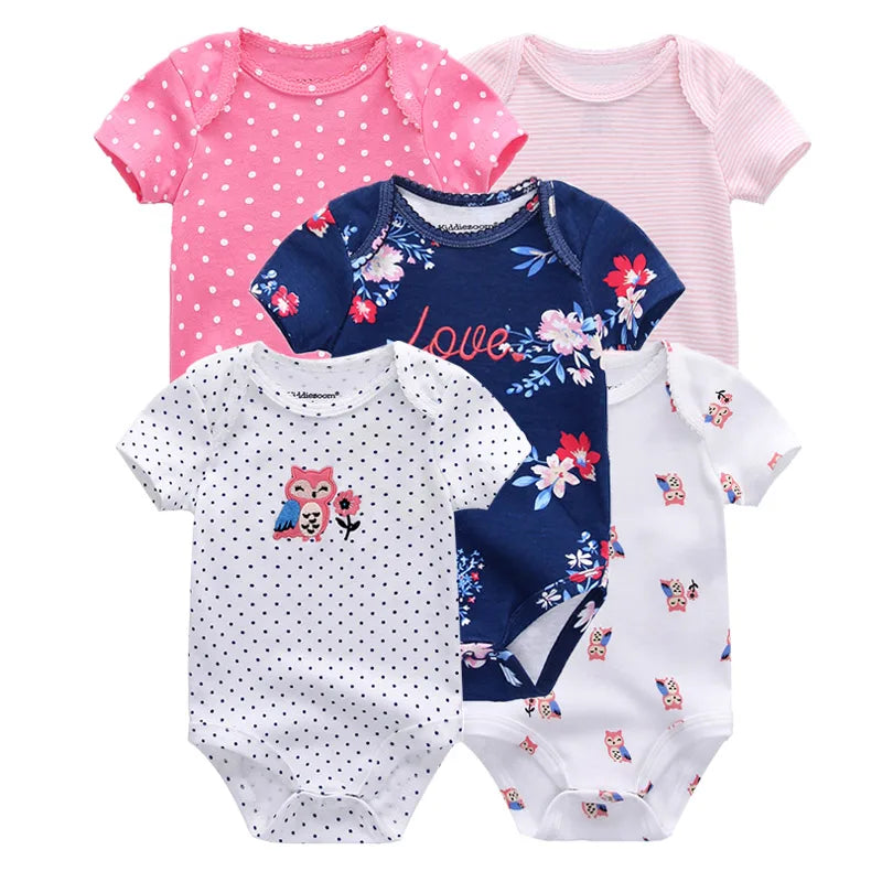 Cinq bodys en coton à manches courtes BABY PREMA pour bébés filles avec divers motifs, notamment des étoiles, des cœurs et un visage de lapin, présentés dans des couleurs rose tendre et blanc.
