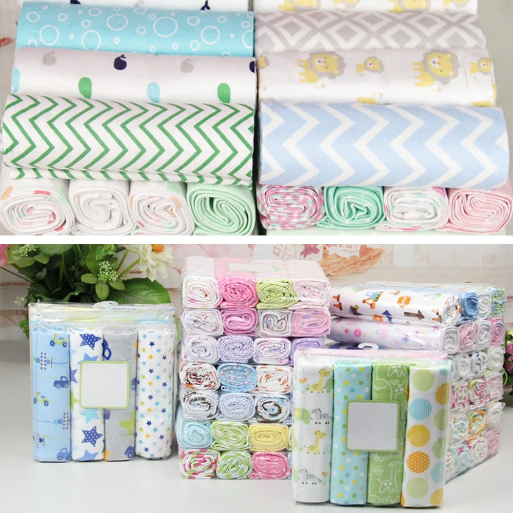 Une variété de lot de 4 langes bébé BABY PREMA, colorés et à motifs, soigneusement pliés et roulés, présentés à