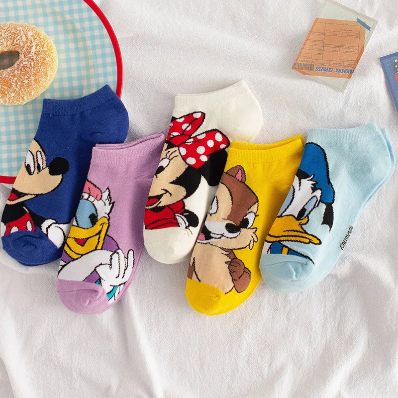 Un ensemble de six chaussettes colorées avec des motifs de personnages de dessins animés, dont Mickey Mouse et Minnie Mouse, est disposé sur une surface blanche. Fabriquées en coton léger et confortable, les BABY PREMA Paire Chaussettes Coton Coréennes présentent des fonds bleu vif, violet, jaune et bleu clair.