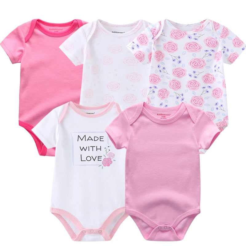 Cinq bodys en coton à manches courtes BABY PREMA pour bébés filles avec divers motifs, notamment des étoiles, des cœurs et un visage de lapin, présentés dans des couleurs rose tendre et blanc.