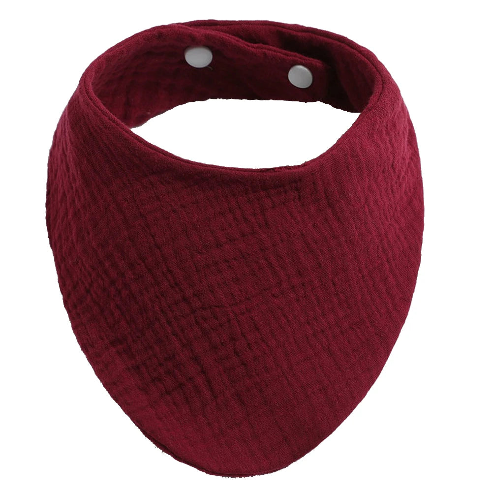 Un accessoire bébé : un Bavoir 100% Coton pour Bébés BABY PREMA en tissu rouge avec des boutons-pression blancs ajustables.