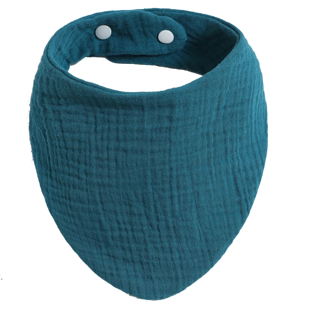 Un Bavoir 100% Coton pour Bébés BABY PREMA en bleu sarcelle avec des boutons-pression blancs ajustables, nécessaires pour l'hygiène du bébé.