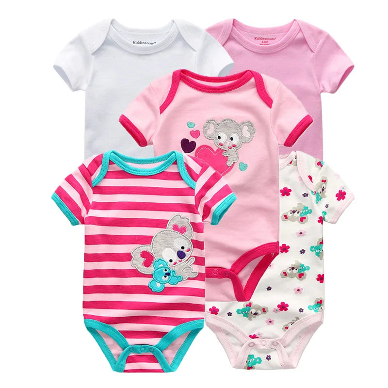 Cinq grenouillères pour bébé, parfaites pour une garde-robe de bébé. Trois de couleur unie ; blanc, rose et rose clair. Deux à motifs ; un à rayures roses avec des koalas et un blanc avec des fleurs et des koalas. Le Pack de 5 Corps | Coton Doux Bébé de BABY PREMA est un cadeau idéal pour les nouveaux parents.