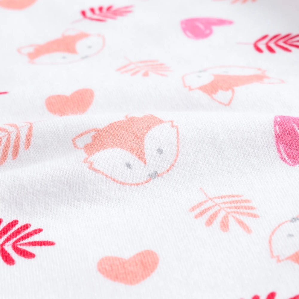 Gros plan de tissu à motif de têtes, de coeurs et de feuilles de renards orange et rose, idéal pour créer Lot de 7 Bodies Bébé Imprimés Unis par BABY-PREMA. Le coton doux assure le confort tandis que le design charmant ajoute une touche ludique.