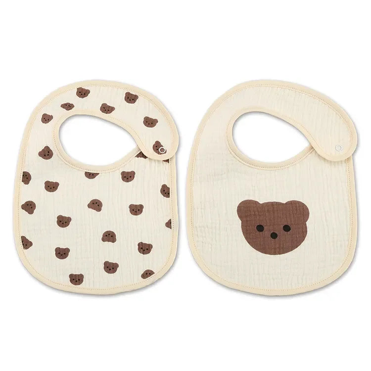 Deux bavoirs bébé aux motifs d'ours. Un bavoir comporte plusieurs petites faces d’ours et l’autre une seule grande face d’ours. Les deux Bavoirs Motifs Bébé 2 Pièces de BABY-PREMA ont des fermetures à pression et sont de couleur crème avec des imprimés d'ours bruns. Le Bandana design ajoute une touche stylée à ces adorables essentiels.