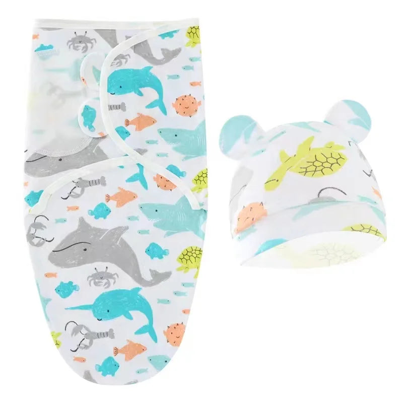 Une paire d'emmaillotages bébé Gigoteuse de la marque BABY PREMA avec des illustrations colorées d'animaux marins, accompagnée d'un bonnet pour bébé assorti avec des oreilles d'an.