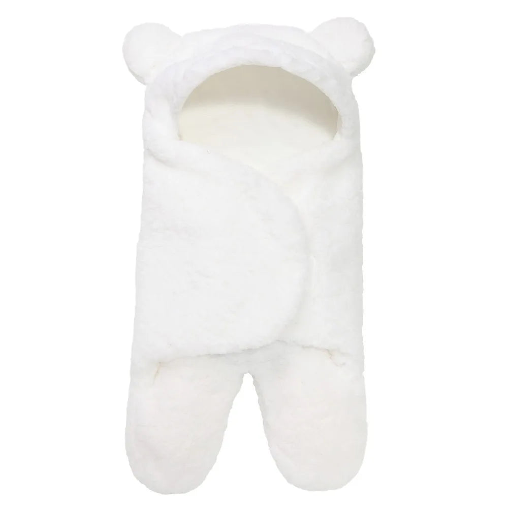 Un Couverture Cocoon Nid d'Ange bébé douillet, un sac de couchage blanc avec capuche ornée d'oreilles d'ours mignonnes de la marque BABY PREMA.