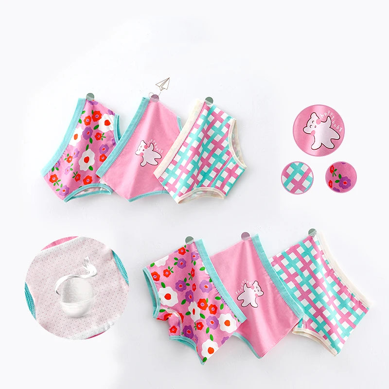Ensemble de vêtements pour enfants comprenant plusieurs paires de shorts et débardeurs colorés avec des motifs floraux et à carreaux, ainsi que des épingles assorties, un échantillon de tissu en gros plan et du coton doux **Lot de 3 Culottes pour Enfants** pour enfants par **BABY PREMA* *.