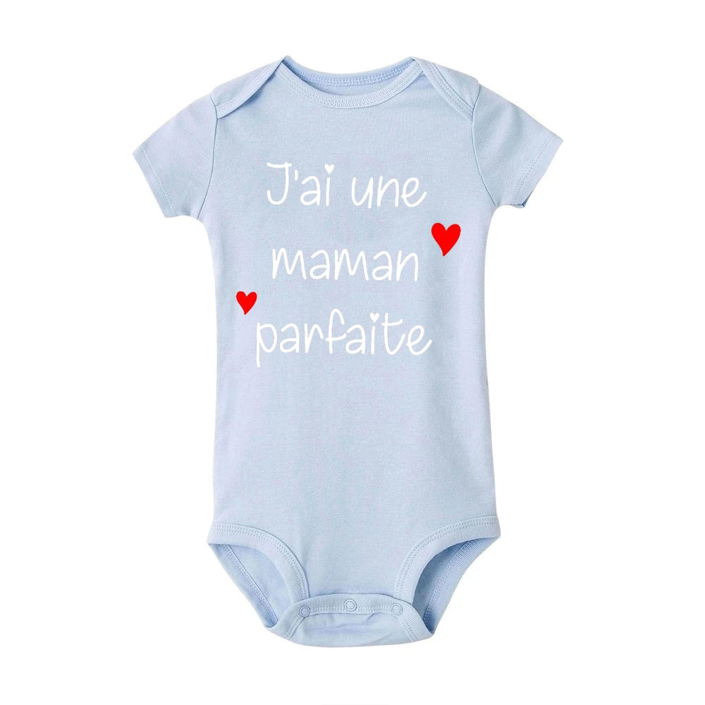 Un Body Bébé Coton Imprimé Préma bleu clair avec des manches courtes et des boutons-pression en bas. Le texte sur la combinaison est en français et dit « J'ai une maman parfaite », qui se traduit par « J'ai une maman parfaite », avec deux petits cœurs rouges qui la décorent – un ajout adorable à toute garde-robe enfant de BABY. -PREMA.