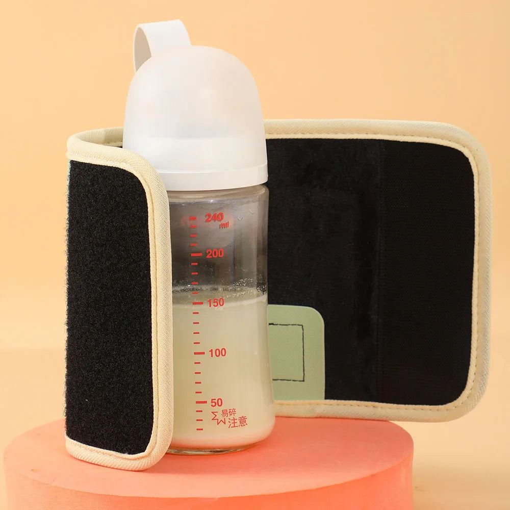 Un biberon avec un bouchon blanc, rempli de liquide, est maintenu par un support isotherme noir et beige muni de bandes velcro. Le flacon comporte des graduations rouges jusqu'à 240 ml. Il est posé sur une surface cylindrique orange sur fond pêche, complété par un Chauffe-Biberon Portable multifonction BABY-PREMA pour plus de commodité.