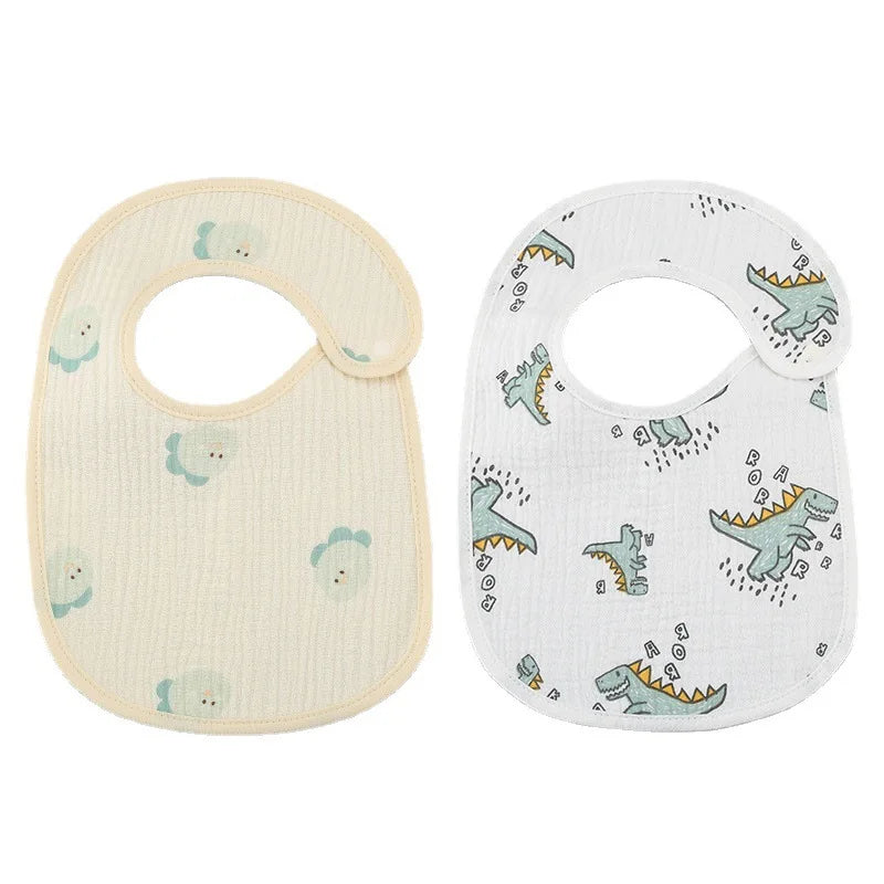 Deux bavoirs bébé sont exposés. L’un est jaune clair avec un motif subtil, et l’autre est blanc avec un imprimé dinosaure ludique. Les deux BABY-PREMA Bavoirs Motifs Bébé 2 Pièces ont une ouverture col rond et un revers imperméable, assurant confort et durabilité.