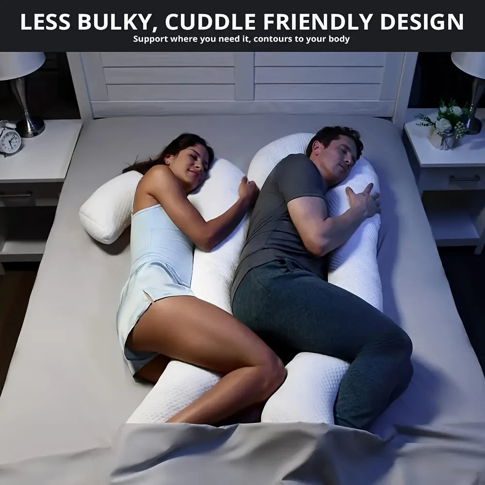 Deux personnes dorment sur un lit, chacune embrassant un grand Coussin Oreiller pour Contour Corps de BABY PREMA qui épouse les contours de leur corps. Le texte ci-dessus se lit comme suit : « Conception moins encombrante et conviviale pour les câlins.