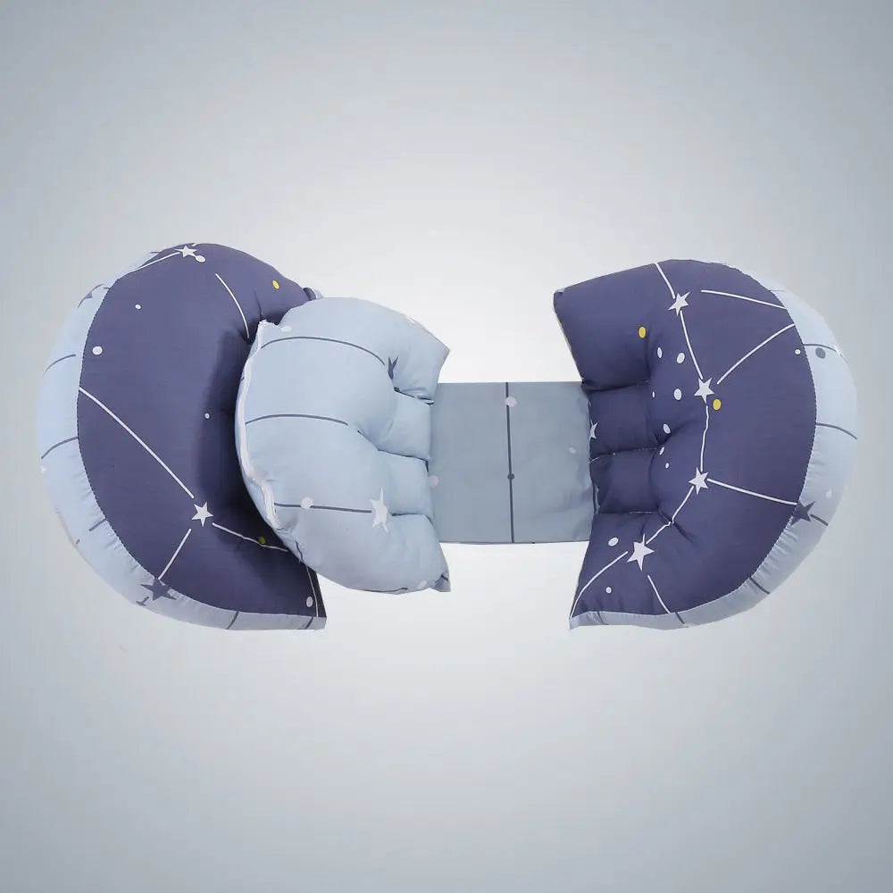 Une chaise longue rembourrée pour bébé présentant un motif de ciel étoilé dans des tons bleu foncé et bleu clair. En forme de papillon avec deux ailes de coussin de chaque côté reliées par une section centrale en tissu, cette chaise longue offre BABY PREMA Coussin de Grossesse Amovible niveaux de soutien et de confort de grossesse, offrant un lieu de repos confortable pour les nourrissons.
