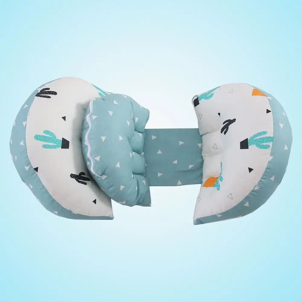 Un Coussin de Grossesse Amovible BABY PREMA avec un oreiller cervical doux en forme de U *oreiller en forme de U* et un coussin de dossier reliés par une bande de tissu. Le tissu présente un joli imprimé avec des cactus, des flèches et des triangles dans des tons de bleu, vert, noir et orange sur un fond blanc.
