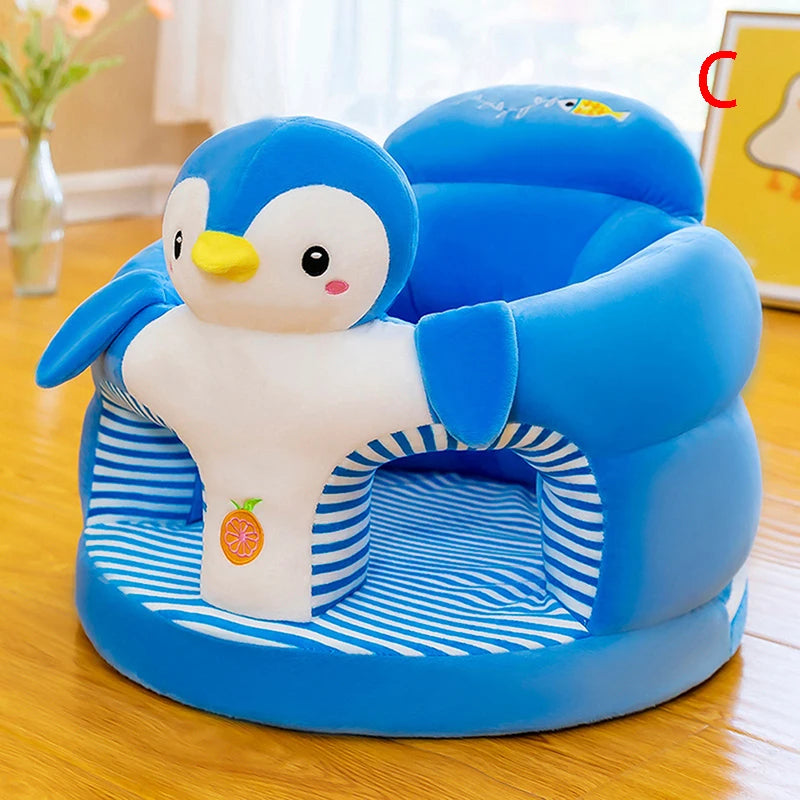 Une jolie Figurine Siège Bébé Amusante bleue et blanche de BABY PREMA en forme de pingouin avec un intérieur rayé et un design de dessin animé ludique. Le pingouin a un bec jaune et des yeux noirs, avec un petit fruit orange sur le devant. Le siège est posé sur un parquet en bois avec une plante et des rideaux blancs en arrière-plan.