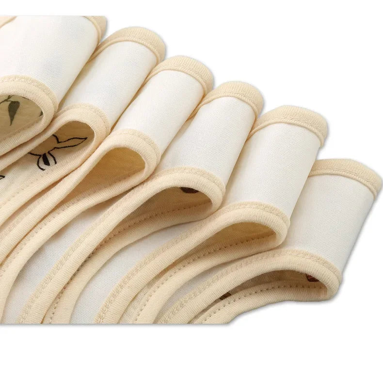 Gros plan de Bavoirs Motifs Bébé 2 Pièces soigneusement empilés avec des bords arrondis, chaque serviette présentant de subtiles coutures décoratives près du bord, rappelant le design bandana classique de BABY-PREMA.