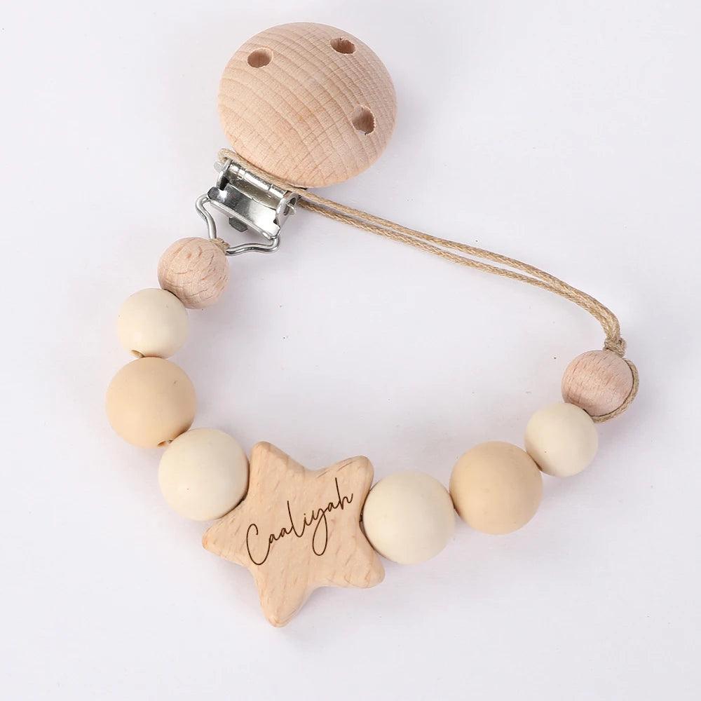 Attache Sucette Bébé Personnalisée avec des perles et une breloque personnalisée en forme d'étoile affichant le prénom "Carolyn", indispensable à l'hygiène de bébé, par BABY-PREMA.