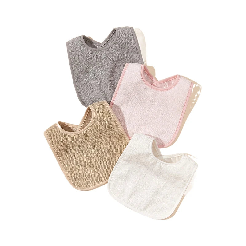Quatre bavoirs bébé disposés en éventail. Ces BABY-PREMA Bavoirs Bébé Lot de 4 Pièces sont disponibles en quatre couleurs différentes : gris, rose, beige et blanc. Chaque bavoir a une texture simple et douce et une forme inférieure arrondie pour plus de couverture. Conçu avec du tissu imperméable pour garder votre bébé au sec et à l'aise pendant les repas.
