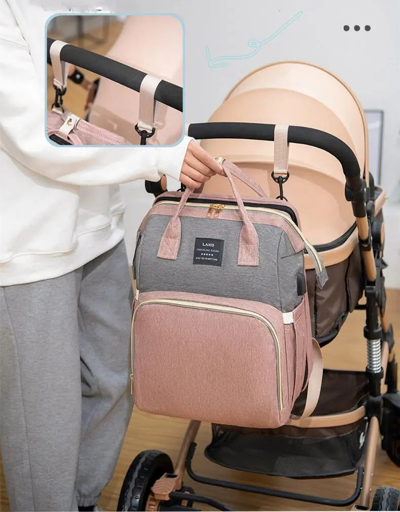 Un sac à langer moderne "Sac à Langer 3 en 1 Pour Maman & Bébé" dans des tons gris et roses élégants, facilement attaché à une poussette, avec un gros plan montrant le mécanisme de fixation de BABY-PREMA.