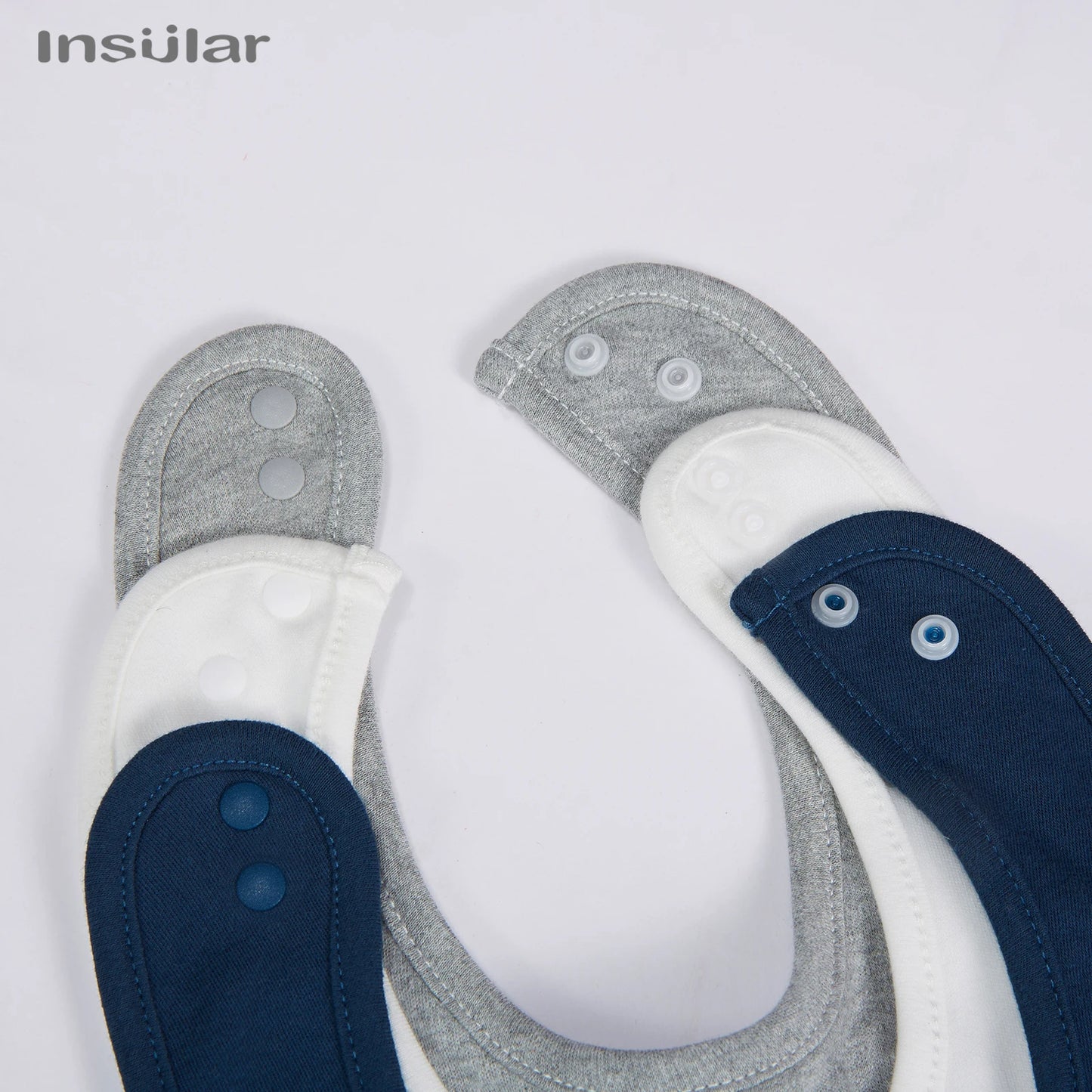 Une vue rapprochée de deux paires d'accessoires bébé de Bavoir Bébé en Coton Bio de la marque BABY PREMA, une argent et l'autre bleue.