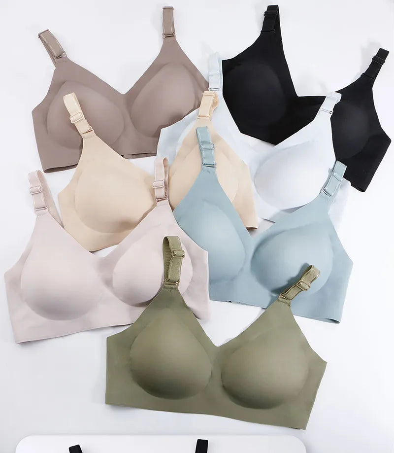 Une variété de soutiens-gorge réglables BABY PREMA Soutien d'allaitement dans différentes couleurs neutres et pastel soigneusement disposés dans une composition à plat inspirée des plumes.