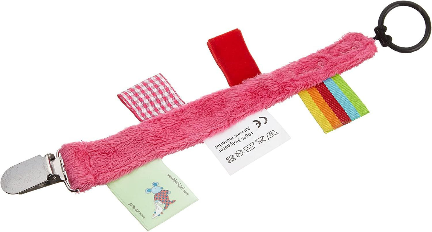 Un jouet sensoriel coloré pour bébé comprenant une sangle en peluche rose avec diverses textures et motifs de tissu, un carré rouge, des rubans à carreaux et à rayures et un anneau noir avec des instructions d'entretien attachées - Attache Sucette de LABEL LABEL.