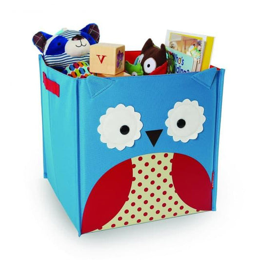 Une Caisse Rangement pour enfants colorée et pliable Hiboux de Skip Hop, remplie de divers jouets et livres pour enfants de Baby Prema.