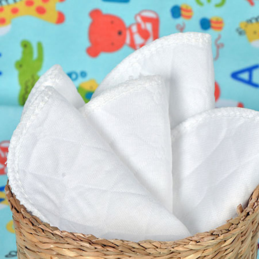 Un panier en osier contenant des mouchoirs blancs soigneusement pliés, avec un fond à motifs coloré et adapté aux enfants, est un accessoire bébé Baby Prema essentiel pour maintenir l'hygiène.