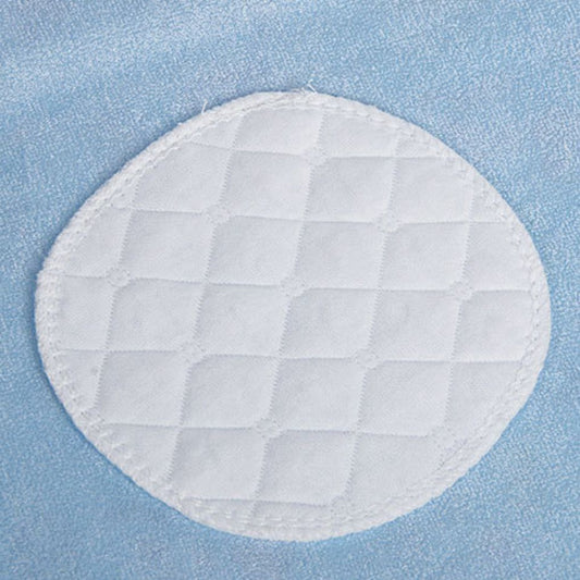 Un gros plan d'un coussinet en tissu matelassé blanc avec des motifs de grilles cousues, conçu comme Coussinets d'allaitement - Baby Prema, placé sur un fond bleu texturé par BABY PREMA.