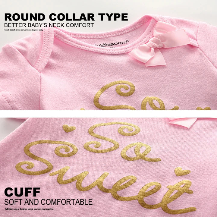 Gros plan sur une chemise bébé rose avec un col rond, un petit nœud et un texte doré disant « So Sweet ». Cette charmante pièce du **Lot 5 Bodys Coton | Imprimés Manches Courtes** de **BABY PREMA** présente des poignets doux et confortables pour votre tout-petit.