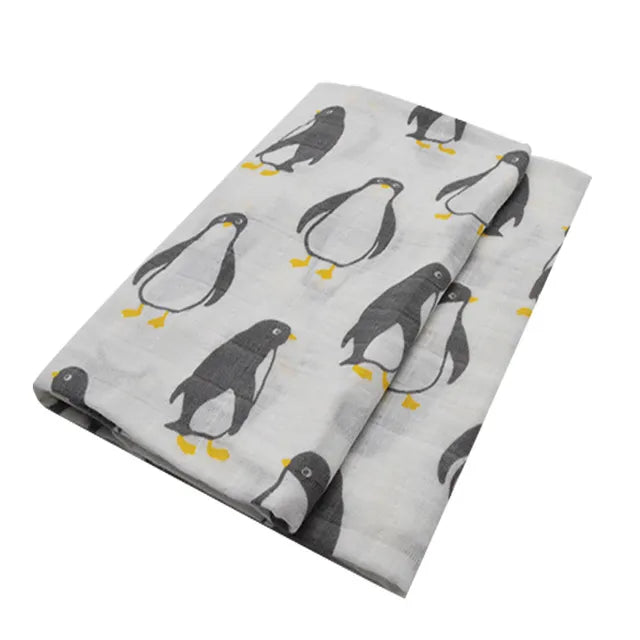 Un Lange Bébé en Coton et Fibre de Bambou gris plié avec un motif répétitif de pingouins de dessins animés, conçu léger pour enfant prématuré par BABY PREMA.