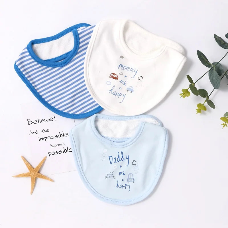 Trois "Lot de 3 pièces Bavoirs Bébé" de BABY-PREMA sont disposés sur une surface blanche avec une petite plante et une étoile de mer. Un bavoir a des rayures bleues et blanches, un autre est blanc avec « maman, moi, heureuse » écrit dessus avec des petits motifs, et le troisième est bleu avec « Papa, moi, heureux » et des petits motifs.