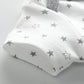 Gros plan sur un tissu blanc avec un motif de petites étoiles grises et un liseré gris, parfait pour BABY-PREMA Lot de 8 Bodies 100% Coton Bébé. La matière est 100 % en coton, assurant confort et douceur à votre tout-petit.