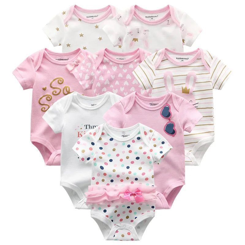 Une collection de sept combinaisons pour bébé dans divers motifs roses et blancs, notamment des pois, des rayures, des cœurs, des étoiles, ainsi que des textes et illustrations décoratifs. Ce Lot de 8 Bodies 100% Coton Bébé de BABY-PREMA est composé à 100% en coton pour un confort ultime.