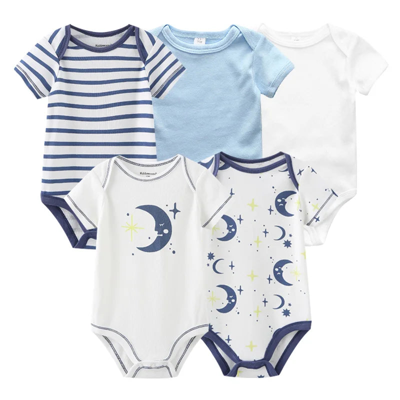 Cinq combinaisons pour bébé de différents motifs et couleurs, dont des rayures, du bleu clair uni, du blanc uni et un motif avec des lunes et des étoiles. Ces Lot 5 Bodys Coton | Les Imprimés Manches Courtes de BABY PREMA sont des vêtements pour bébé parfaits pour la garde-robe de tout petit.