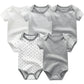 Cinq grenouillères pour bébé sont présentées, présentant des motifs différents : blanc uni, gris à rayures blanches, blanc à rayures grises, blanc à étoiles grises et gris uni. Ce Pack de 5 Bodies Coton Doux Bébé de BABY PREMA constitue un cadeau de naissance idéal pour tout bébé.