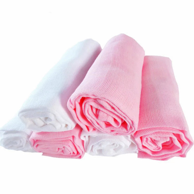 Trois langes couvertures & canapés bébé en coton de la marque BABY PREMA, roulés en blanc et rose, destinés à un enfant prématuré, sont posés contre un fond blanc.