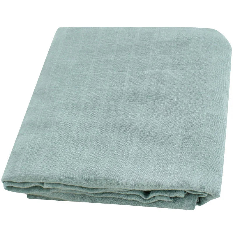 Une couverture en lin gris clair soigneusement pliée avec une subtile texture à carreaux, parfaite pour un BABY PREMA prématuré bébé : Lange Couverture bébé | Emmaillotage Mousseline Bambou.