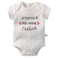 Un Body Manches Courtes Coton blanc à manches courtes arbore le texte imprimé "ATTENTION !!! PAPI, MAMIE,… J'ARRIVE", accompagné de deux petits coeurs rouges. Ce body annonce nouveau-né de BABY-PREMA est fabriqué en coton doux et possède des fermetures à pression au bas.