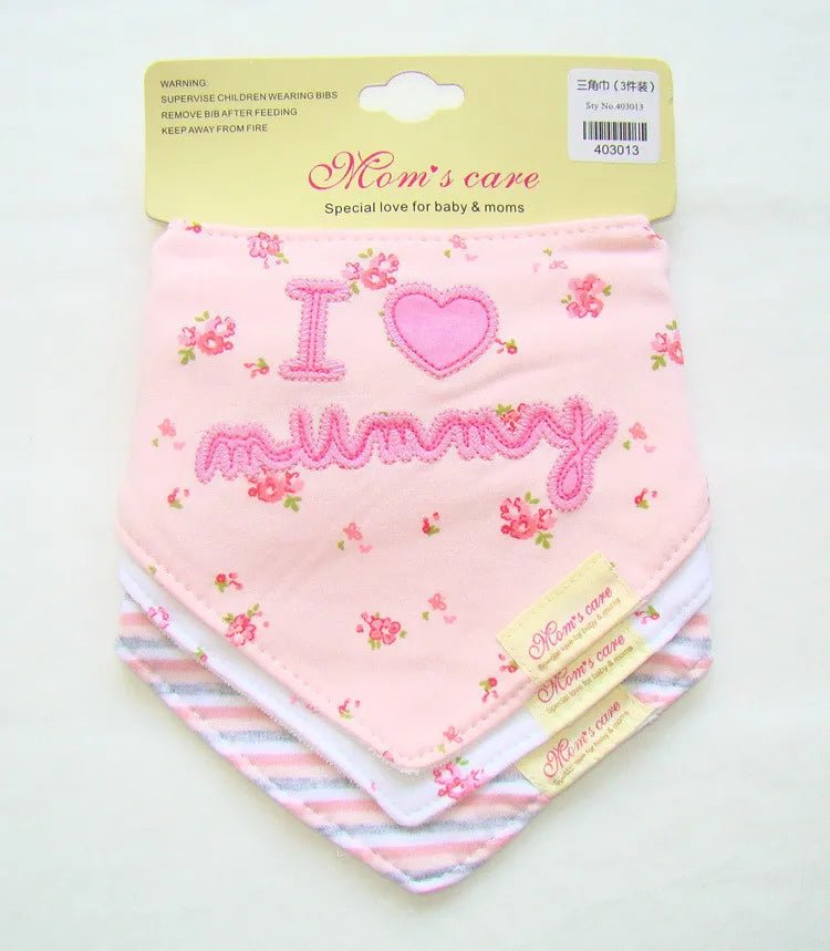 Un lot de trois bavoirs bébé roses (Lot de 3 Bavoirs 100% Coton) de BABY-PREMA est présenté, chacun présentant de délicats motifs floraux. Le bavoir supérieur porte un message brodé « I ♥ maman » en fil rose. L'emballage indique « Les soins de maman : un amour spécial pour bébé et les mamans. » Les consignes de sécurité sont imprimées sur l'emballage.