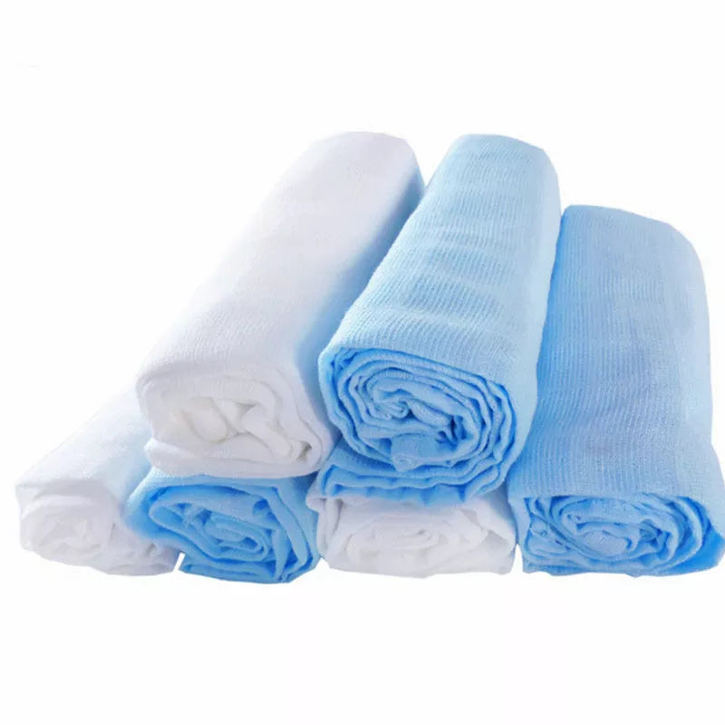 Un ensemble de serviettes légères Baby Prema blanches et bleu clair soigneusement roulées sur fond blanc.