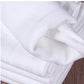 Vue rapprochée d'une pile de Langes Couvertures & Couches Bébé en Coton doux et blancs de BABY PREMA, éventuellement des serviettes ou du linge de maison, mettant en valeur la texture et les plis.