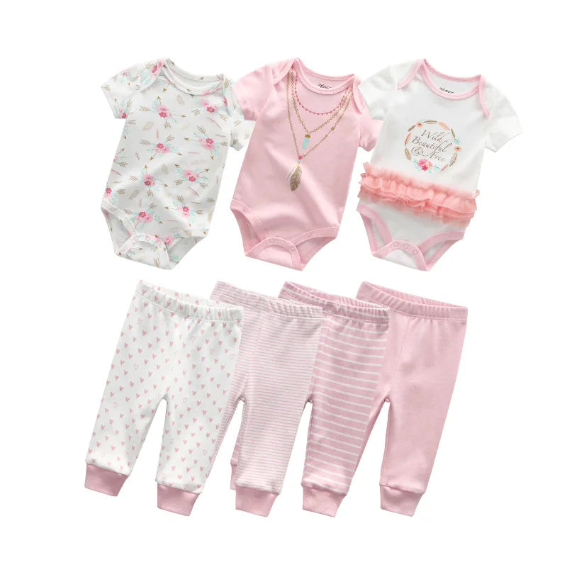 Cette collection de six pièces Kit Ensemble Body Pantalons Bébé de BABY PREMA comprend trois combinaisons à manches courtes et trois pantalons. Les combinaisons présentent des motifs floraux, roses avec un imprimé collier et blancs avec un motif « Wild & Beautiful ». Le pantalon en coton respirant est blanc avec des cœurs roses, rose clair avec des rayures et rose uni.