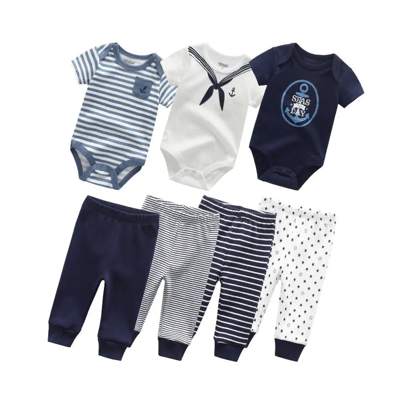 Un Kit Ensemble Body Pantalons Bébé de BABY PREMA est présenté, comprenant trois combinaisons en bleu marine, blanc et blanc avec des rayures bleu marine, chacune ornée de thèmes nautiques comme des ancres. De plus, il existe quatre pantalons en bleu marine, bleu marine à rayures blanches et blanc avec de petits motifs nautiques.