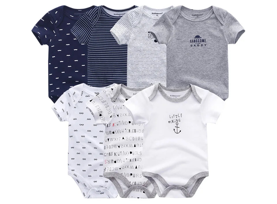 Six grenouillères BABY PREMA Lot de 6 Pièces Body Coton Bébé de différents motifs et couleurs, dont le bleu, le gris et le blanc, avec différents imprimés et motifs de texte affichés sur deux rangées. Chaque body manches courtes est confectionné en coton doux pour un confort maximal.