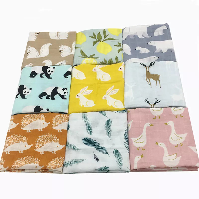 Un assortiment coloré d'échantillons de tissu BABY PREMA Lange Bébé en Coton et Fibre de Bambou avec divers motifs mignons de dodo et d'animaux soigneusement disposés en rangées sur un fond blanc.